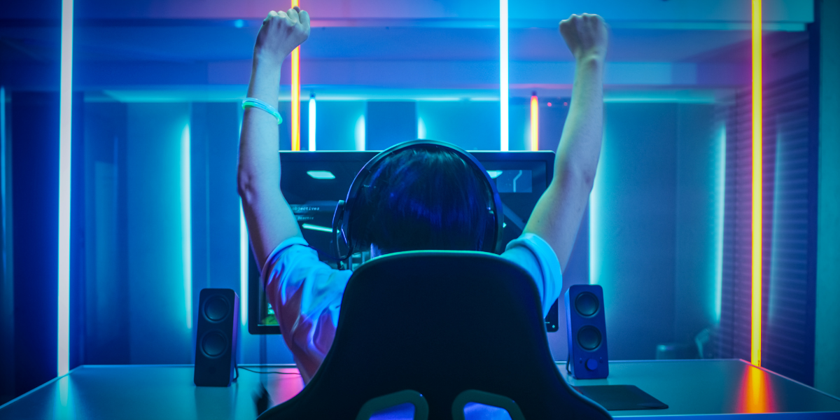 Online gamer in chair raising hands