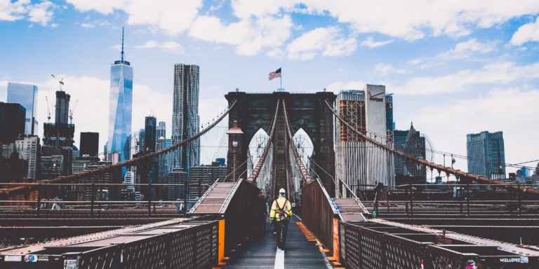 An individual walking over a bridge in New York